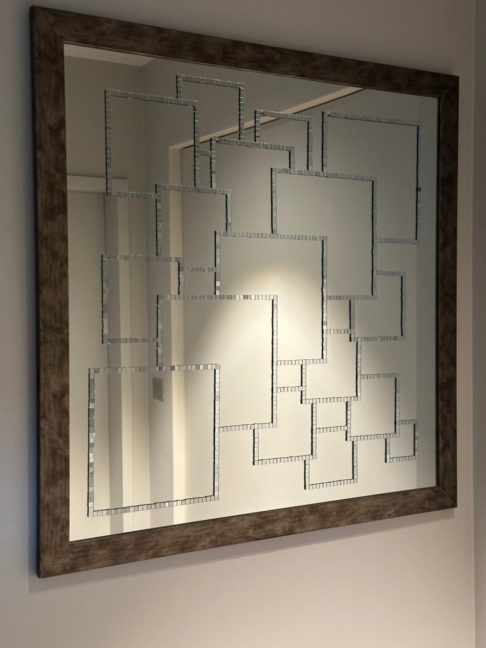 Large framed mirror adorned with interlocking squares of mirror mosaic